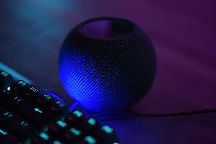 a blue speaker sitting next to a keyboard